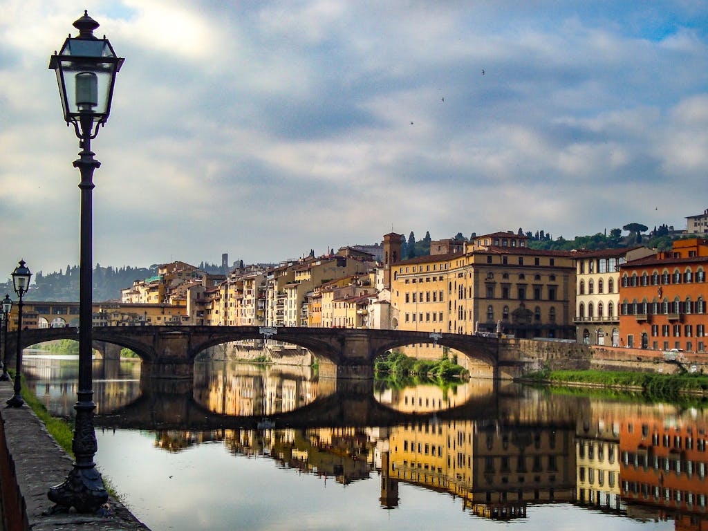 A breathtaking view of Florence's architecture reflecting in the river at dusk, capturing the vibrant essence of Italy.